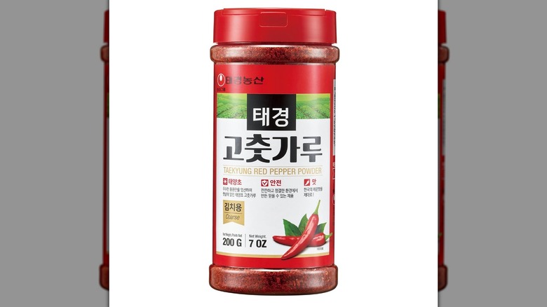 Una botella de condimento Taekyung gochugaru sobre un fondo blanco.