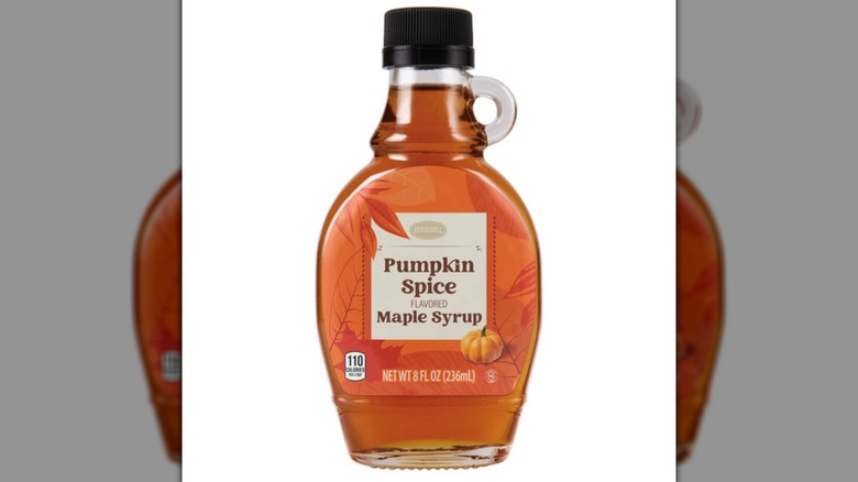 Una botella de jarabe de arce de especias de calabaza especialmente seleccionado sobre un fondo blanco