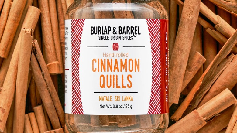 Tarro de canela de arpillera y barril sobre corteza de canela