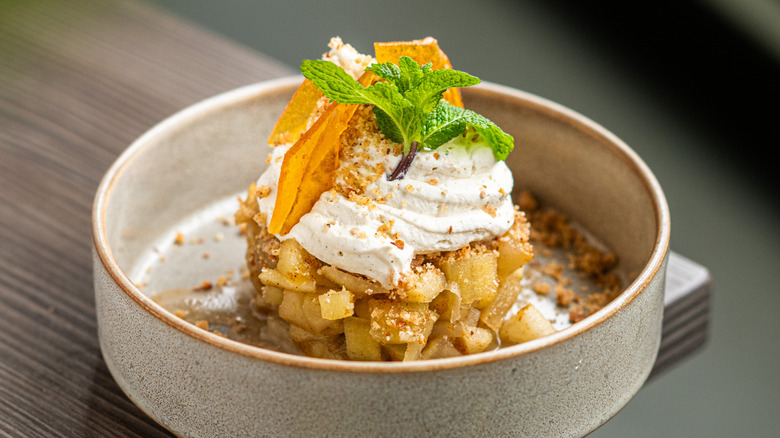Un postre crujiente de manzana con crema, cítricos confitados y hojas de menta.