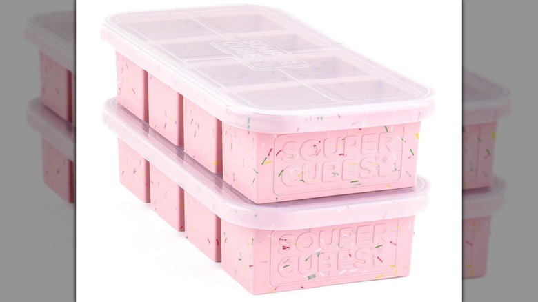 Un paquete de dos moldes para congelador Souper Cubes de color rosa con tapas sobre un fondo blanco