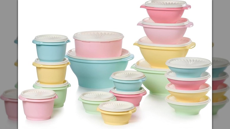 Un juego de 18 recipientes Tupperware Heritage con tapas en colores pastel sobre fondo blanco.