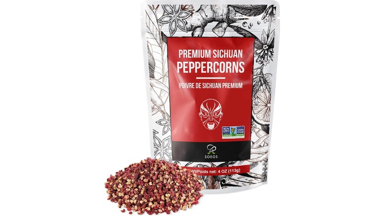 Bolsa de granos de pimienta de Sichuan junto a un montón de granos de pimienta de Sichuan
