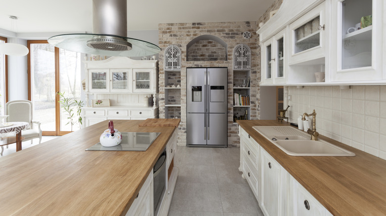 Cocina grande y luminosa con frigorífico de acero inoxidable y encimeras de madera.