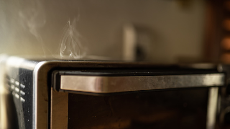 Primer plano de un horno tostador fumando desde arriba