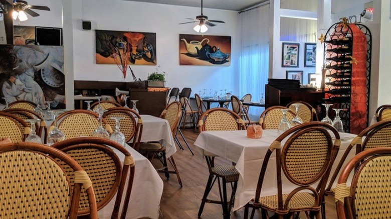 Dentro de Le Bistro con mesas puestas y listas para el servicio.