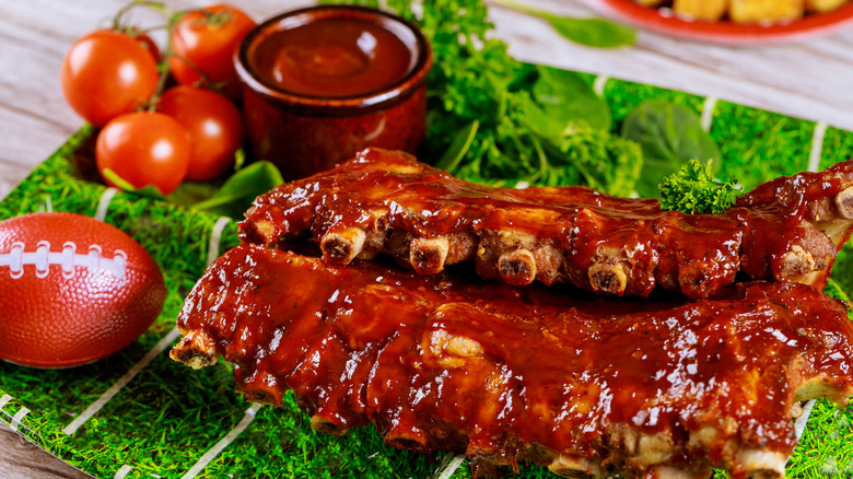 Costillas a la barbacoa con salsa barbacoa en un plato de papel de campo de fútbol