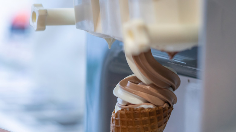 Helado suave de chocolate y vainilla dispensado desde una máquina de servicio suave