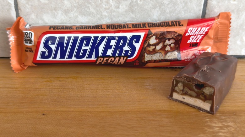 Barra de Pecan Snickers con un trozo cortado por la mitad