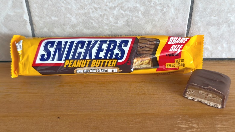 Barra Snickers de mantequilla de maní con un trozo cortado por la mitad