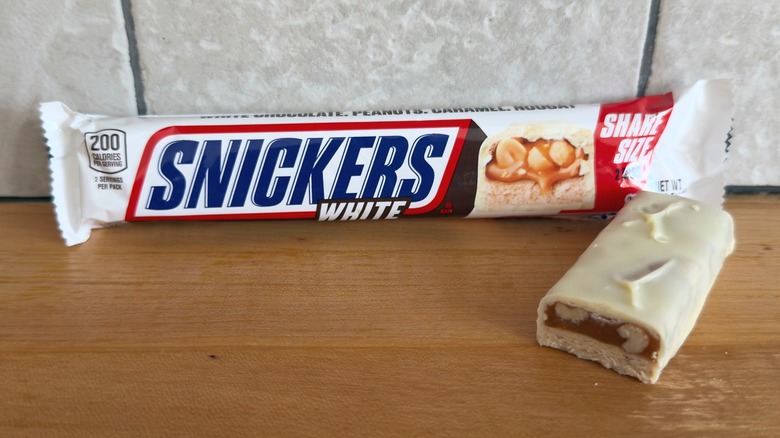 Barra de Snickers blanca con trozo cortado por la mitad