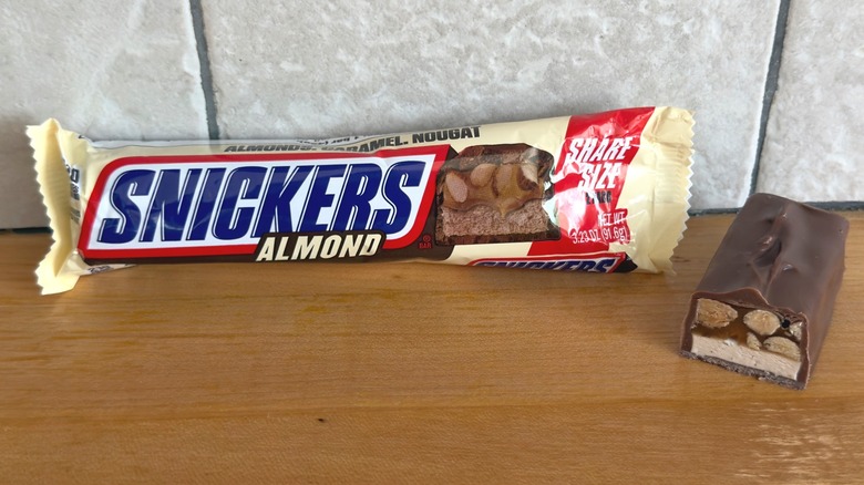 Barra de Snickers de almendras con trozo cortado por la mitad