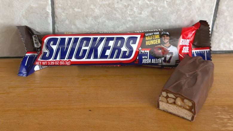 Original barra de Snickers con trozo cortado por la mitad