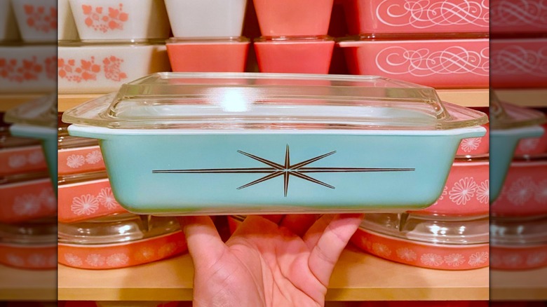 Persona sosteniendo un plato de Pyrex con explosión atómica de color turquesa de Cenicienta