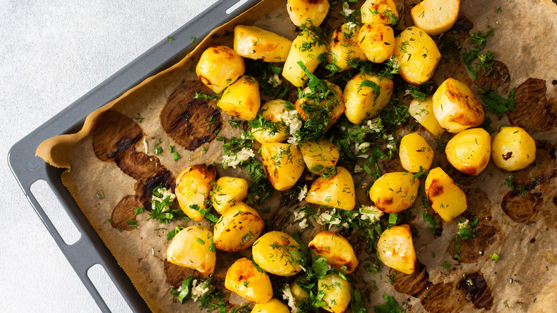 Patatas asadas con hierbas en una bandeja para hornear
