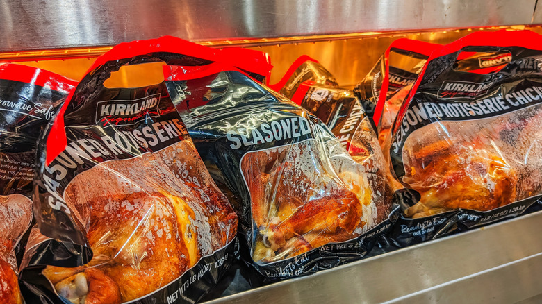 Las bolsas de pollo asado Kirkland se encuentran bajo lámparas de calor.