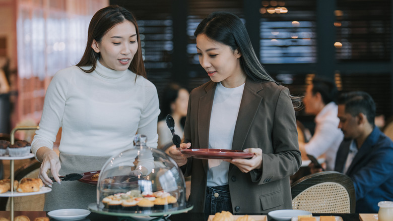 Mujeres con pasteles en buffet