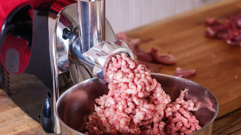 Carne molida en una picadora de carne.