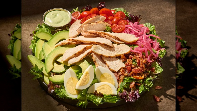 Ensalada Cobb de pollo de la Diosa Verde de Panera sobre un fondo marrón