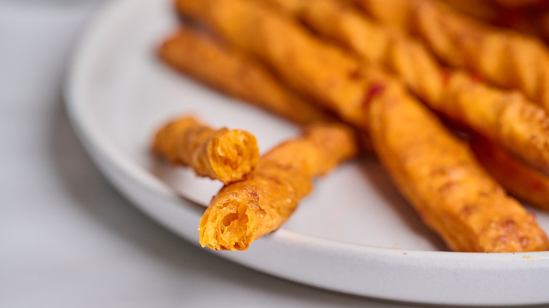 Pajita de queso partida por la mitad para mostrar el interior.