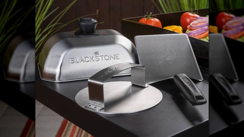 Kit de hamburguesas Smash de 3 piezas Blackstone en una parrilla, junto a varias verduras
