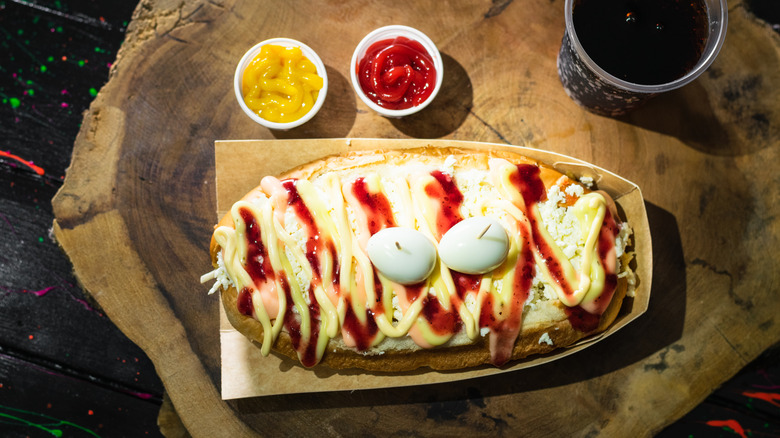 Hot dog estilo colombiano con ketchup y mostaza en tarritos