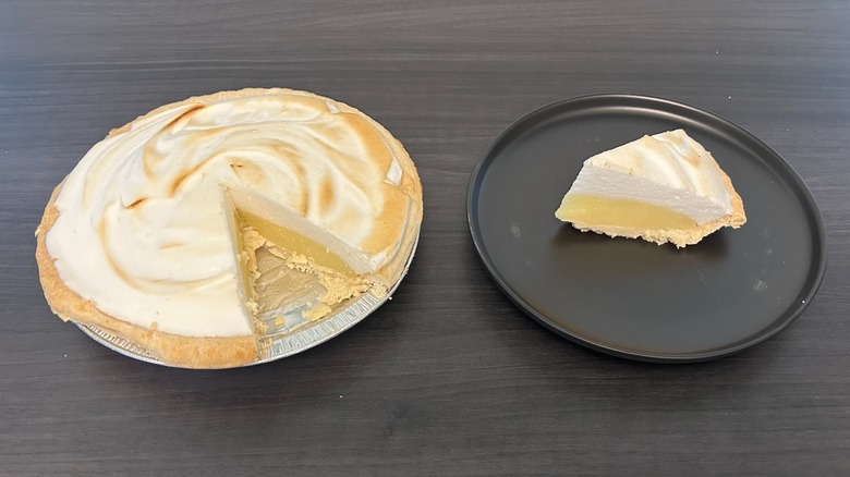Tarta de merengue de limón de Schnuck a la que le falta una rodaja y la rodaja en un plato negro