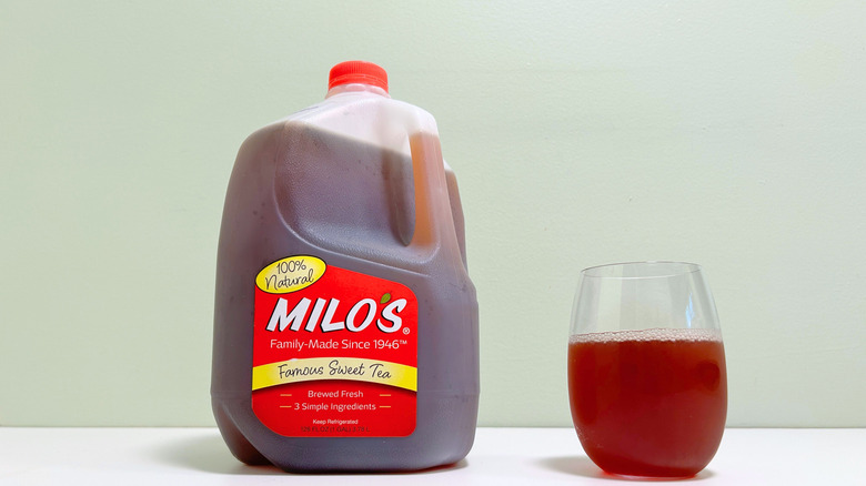 Una jarra de un galón de la famosa red de té dulce de Milo por un vaso casi lleno