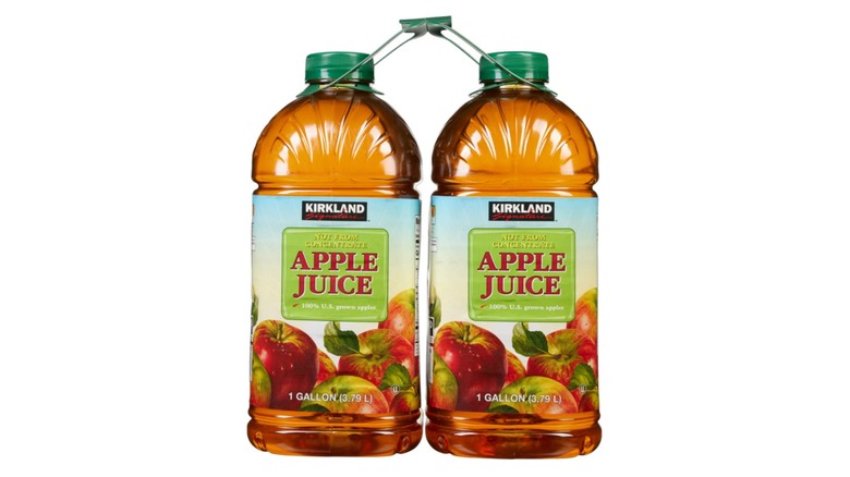 Botellas de jugo de manzana sobre fondo blanco.