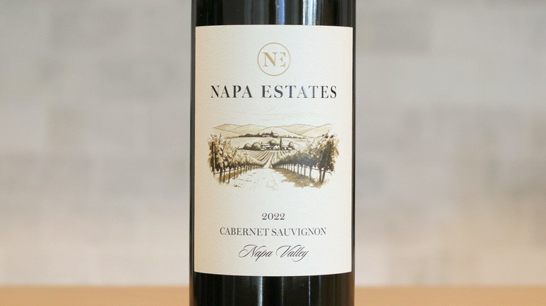 Un primer plano de una botella de Napa Estates Cabernet Sauvignon y una etiqueta en la mesa