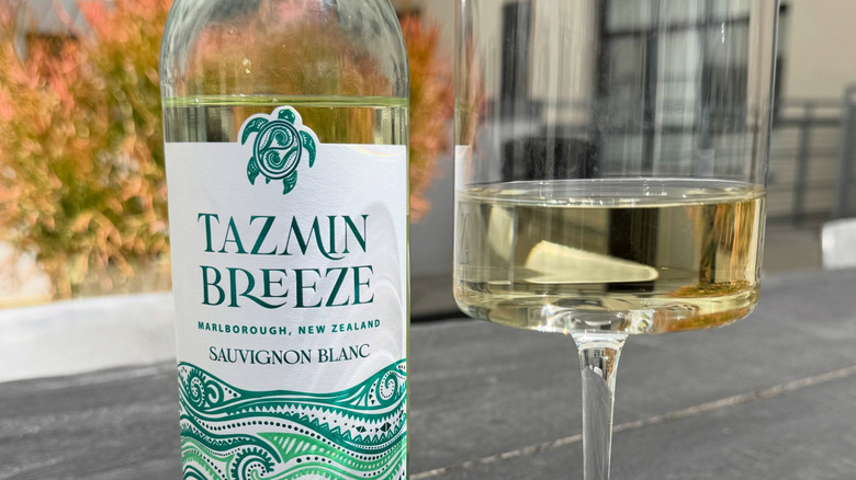 Botella de Tazmin Breeze con vino servido en una copa de vino