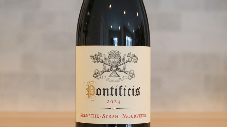 Primer plano de una botella Pontificis GSM sobre la mesa con un fondo gris borroso