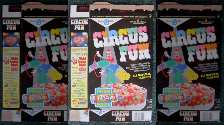 El frente de una caja de cereal Circus Fun sobre un paño verde azulado oscuro