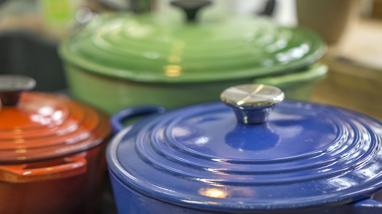Primer plano de la tapa de un horno francés azul, con más hornos franceses al fondo