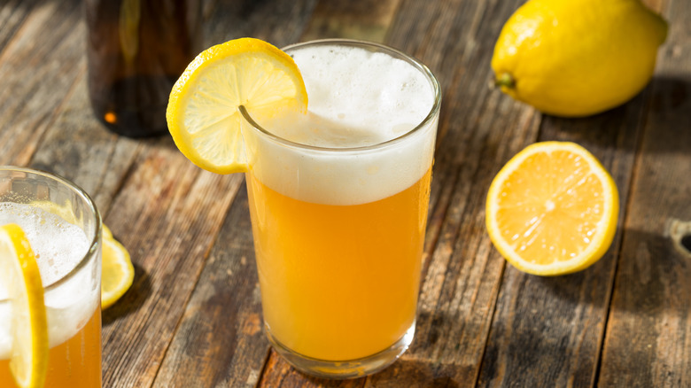 Un shandy de limón con una rodaja de limón.