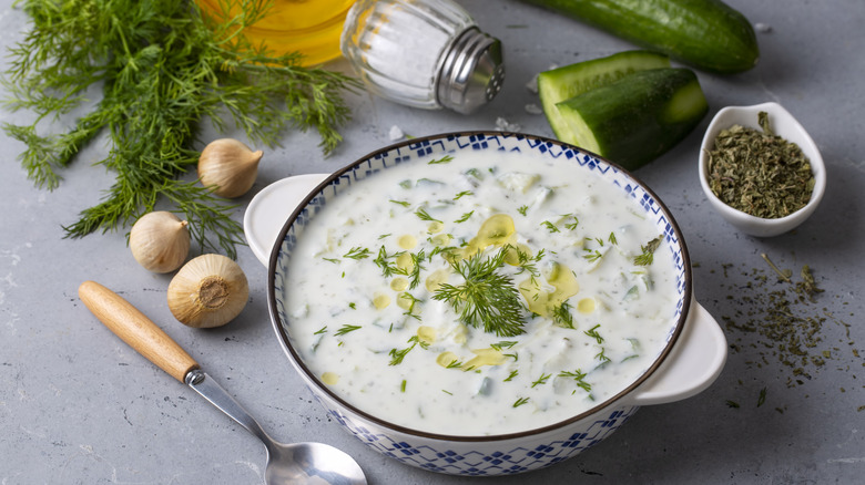 Tazón de tzatzki con pepino, especias y ajo al fondo