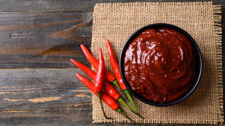 Pasta de gochujang en un bol junto a los chiles
