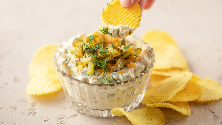 salsa de pepinillos en un recipiente de vidrio con patatas fritas