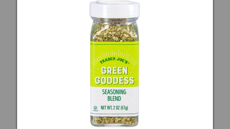 Una botella de mezcla de condimentos Trader Joe's Green Goddess sobre un fondo blanco.