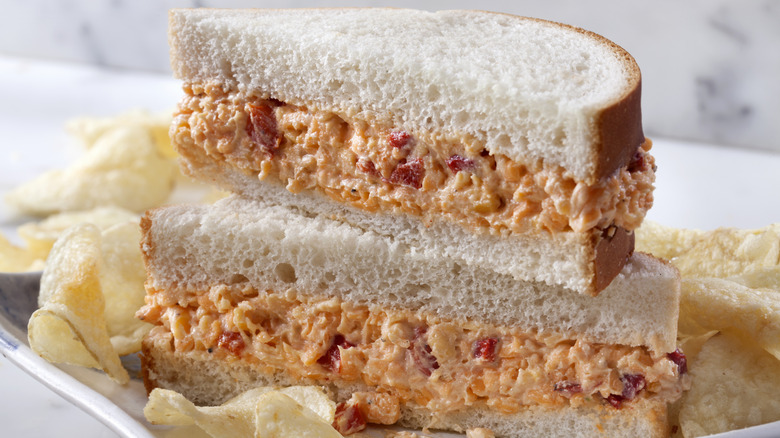 Sándwich de queso pimiento sobre pan blanco con patatas fritas