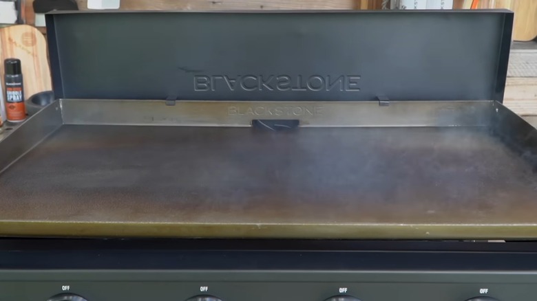 Una plancha Blackstone humeante mientras se sazona