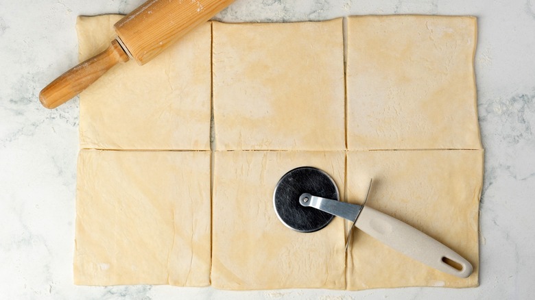 Cortador de masa encima de la masa con líneas rectas cortadas