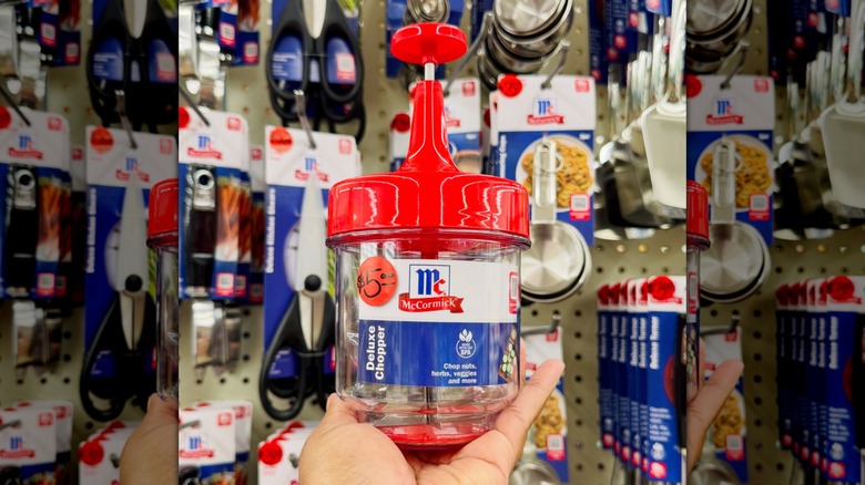 Una mano sosteniendo una picadora de alimentos McCormick en la tienda
