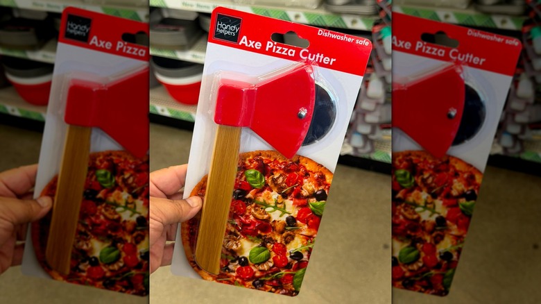 Una mano sosteniendo un cortador de pizza Handy Helpers Axe en la tienda