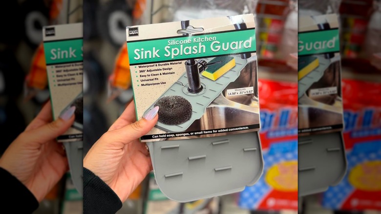 Una mano sosteniendo un protector contra salpicaduras de silicona para fregadero de cocina en la tienda