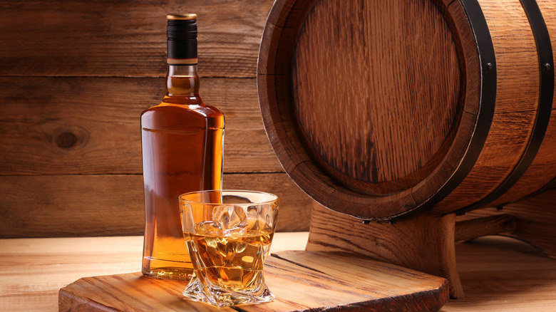 Una botella de whisky y un barril.