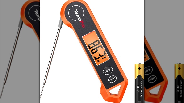 Termómetro digital naranja y batería.