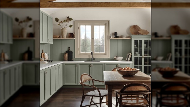 Cocina de estilo rural verde en tonos naturales con mesa de madera.