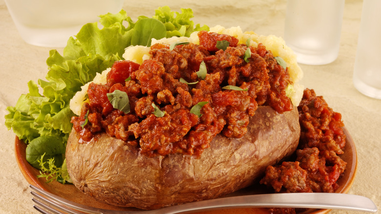 Patata al horno con salsa boloñesa en un plato