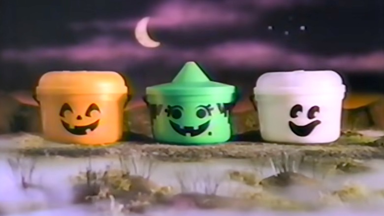 Tres Boo Buckets de McDonald's sobre un fondo oscuro y espeluznante